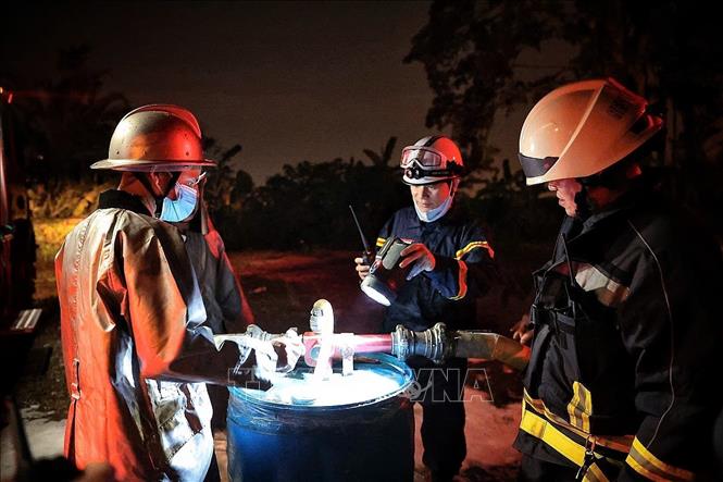 Do khu vực cháy có chứa cac phụ phẩm xăng dầu khiến việc dập lửa và cứu hộ gặp rất nhiều khó khăn. Hiện lực lượng chức năng cơ bản khống chế đám cháy và đang nỗ lực xử lý triệt để khu vực xảy ra hoả hoạn. Ảnh: Phạm Tuấn Anh - TTXVN