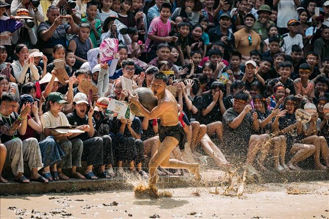 Một quan cầu ôm chặt quả cầu gỗ, bứt tốc trên sân bùn trong tiếng reo hò của hàng trăm khán giả. Không khí tại lễ hội nhiều lúc cuồng nhiệt chẳng kém một trận bóng lớn. Ảnh: Phạm Tuấn Anh - TTXVN