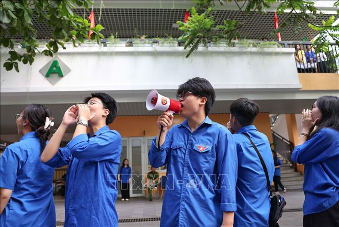 Tuổi trẻ Trường THPT Việt Đức luôn đồng hành, hỗ trợ và động viên các thí sinh tại điểm thi Trường THCS Ngô Sĩ Liên. Ảnh: Thanh Tùng - TTXVN