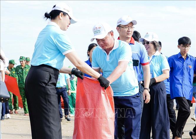 Bí thư tỉnh ủy Nghệ An Nguyễn Khắc Thận tham gia làm sạch bãi biển Cửa Lò. Ảnh: Trịnh Duy Hưng-TTXVN	