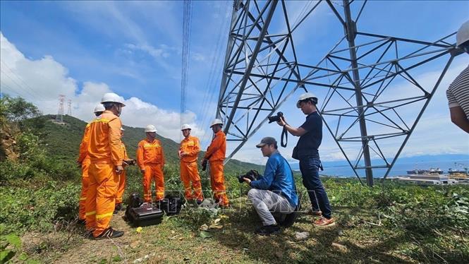 Phóng viên TTXVN đưa tin ảnh về việc hoàn thành đường dây 500kV mạch 3 để đảm bảo việc cung ứng điện thông suốt trên cả nước. Ảnh: TTXVN