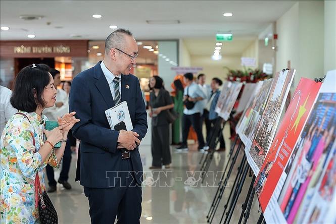 Ông Macro Della Seta, Đại sứ Italia tại Việt Nam xem trưng bày ảnh của báo Viet Nam News & Law. Ảnh: Phạm Tuấn Anh - TTXVN
