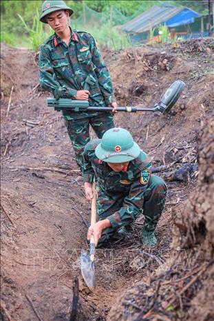 Các thành viên Đội tìm kiếm, quy tập hài cốt liệt sĩ tìm kiếm, xử lý bom mìn, vật liệu nổ còn sót lại, đảm bảo đẩy nhanh tiến độ tìm kiếm nhưng phải tuyệt đối an toàn tại thực địa. Ảnh: Hoàng Hiếu - TTXVN