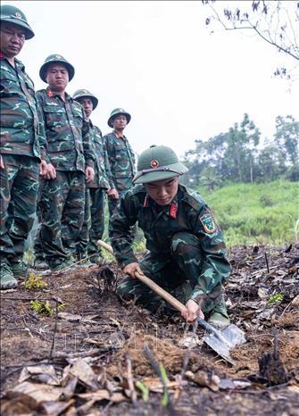 Các thành viên Đội tìm kiếm, quy tập hài cốt liệt sĩ tìm hiểu, sử dụng thành thục máy dò mìn để đảm bảo sạch bom mìn, vật liệu nổ trong khu vực trước khi tiến hành tìm kiếm. Ảnh: Hoàng Hiếu - TTXVN