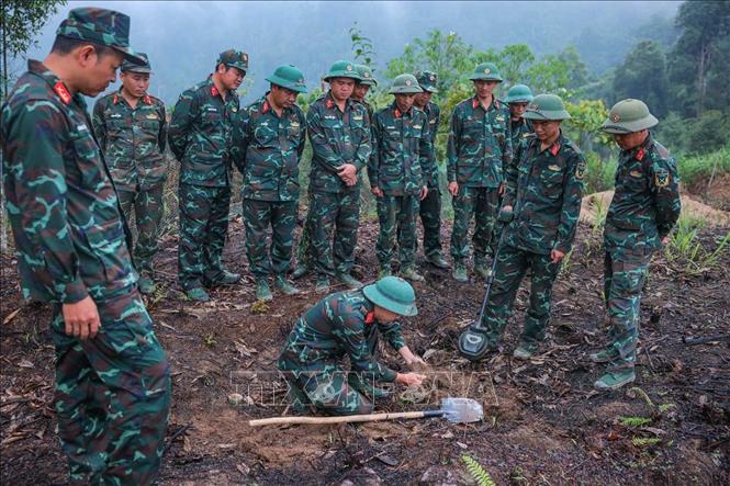 Các thành viên Đội tìm kiếm, quy tập hài cốt liệt sĩ sử dụng máy dò mìn để đảm bảo khu vực tìm kiếm 
