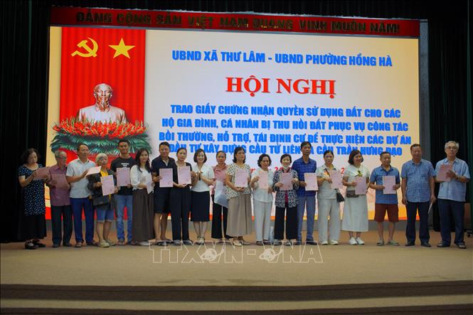 Người dân nhận Giấy chứng nhận quyền sử dụng đất. Ảnh: Kim Anh - TTXVN