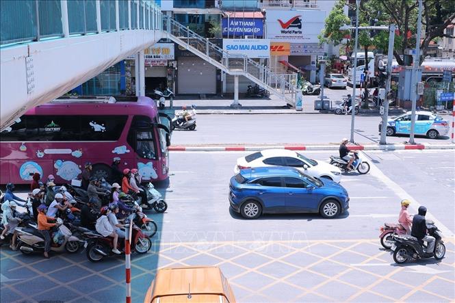 Người tham gia giao thông trên đường Trần Khát Chân dừng xe dưới bóng cầu vượt tránh ánh nắng gay gắt trong lúc chờ đèn tín hiệu giao thông. Ảnh: Hoàng Hiếu - TTXVN