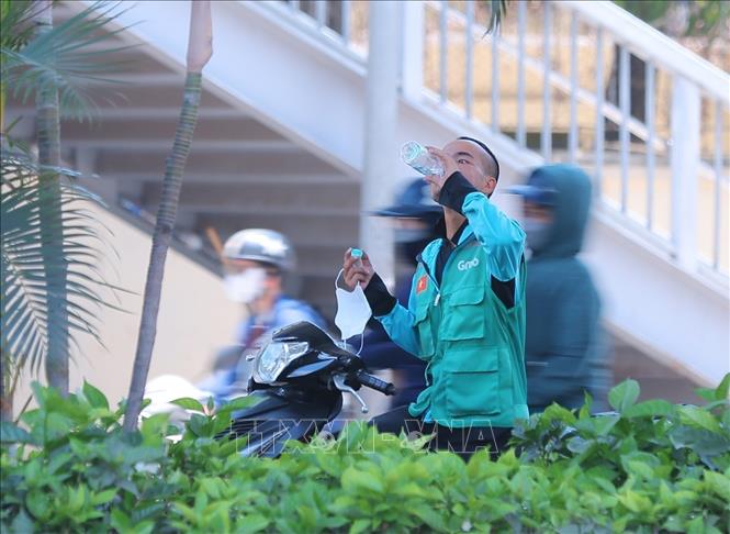 Người lao động ngoài trời phải làm việc dưới nền nhiệt cao cùng không khí oi bức khiến công việc trở nên nhọc nhằn hơn, cần bổ sung đầy đủ nước tránh nguy cơ mất nước sốc nhiệt. Ảnh: Hoàng Hiếu - TTXVN