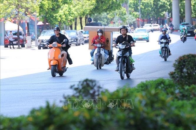 Dưới nền nhiệt ngoài trời vượt 40 độ C, nhiều người đi xe máy có xu hướng di chuyển vào khu vực bên trái đường Trường Chinh - nơi bóng râm dọc tuyến đường để tránh nắng. Ảnh: Hoàng Hiếu - TTXVN