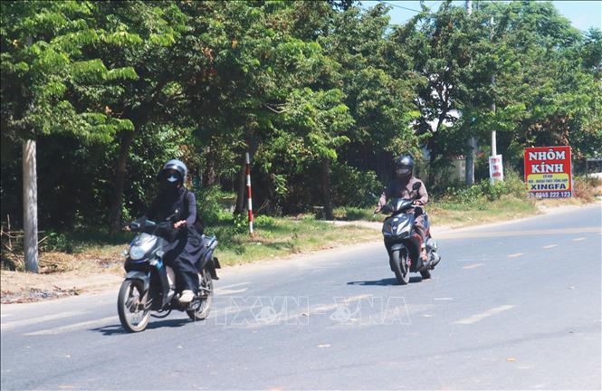 Người dân xã Triệu Phong mặc kín khi ra đường để tránh nắng. Ảnh: Tường Vi - TTXVN. 