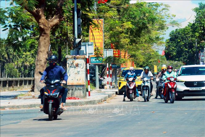 Người dân tại phường Quảng Trị mặc kín khi ra đường để tránh nắng. Ảnh: Tường Vi - TTXVN. 
