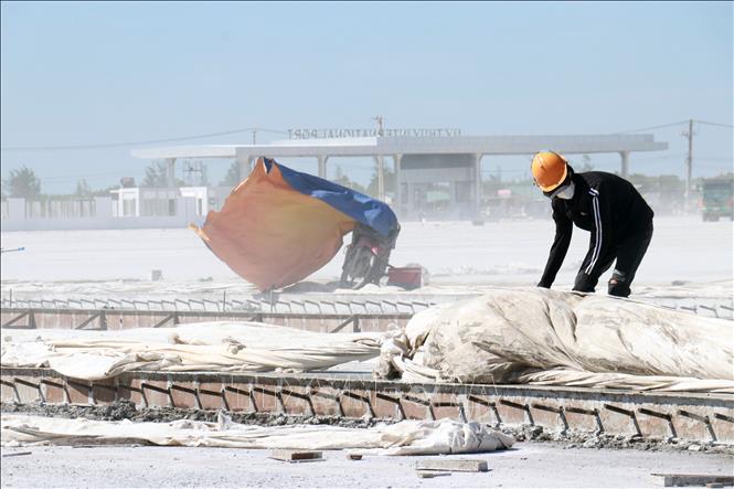 Công nhân mặc kín để tránh nắng tại công trường thi công Dự án Khu bến cảng Mỹ Thủy. Ảnh: Tường Vi - TTXVN. 