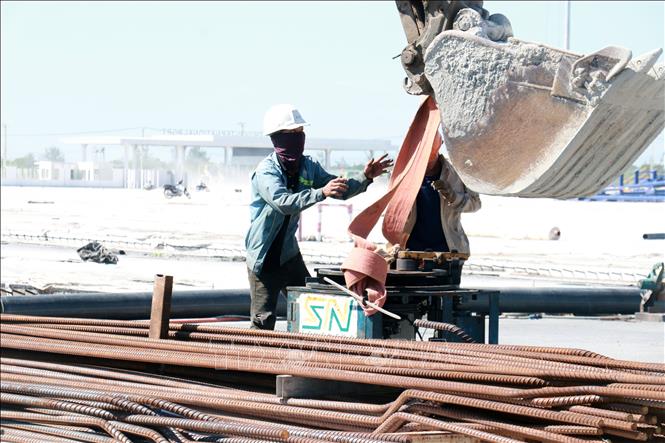 Công nhân mặc kín để tránh nắng tại công trường thi công Dự án Khu bến cảng Mỹ Thủy. Ảnh: Tường Vi - TTXVN. 