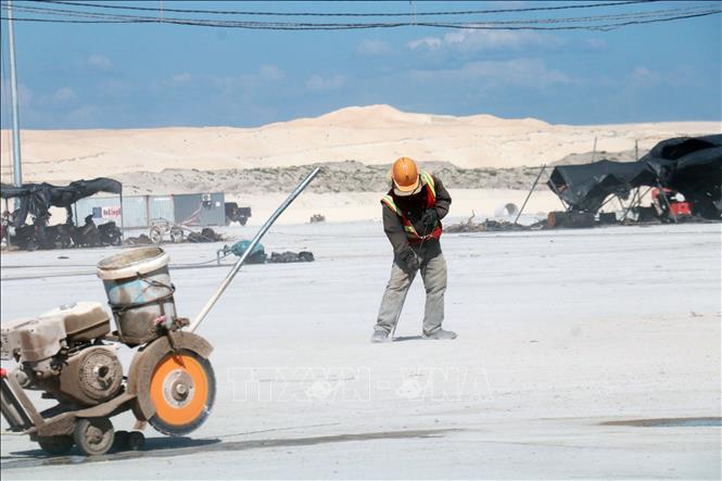 Công nhân mặc đồ bảo hộ tránh nắng trên công trường. Ảnh: Tường Vi - TTXVN. 