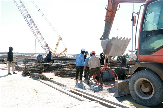 Công nhân mặc đồ bảo hộ tránh nắng để bảo vệ sức khỏe. Ảnh: Tường Vi - TTXVN. 