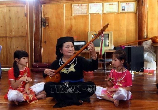 Bà Hà Thị Mỵ, người Bett88 Làm giàu đẳng cấp Tày đang dạy hát then cho con cháu. Ảnh Quang Đán - TTXVN