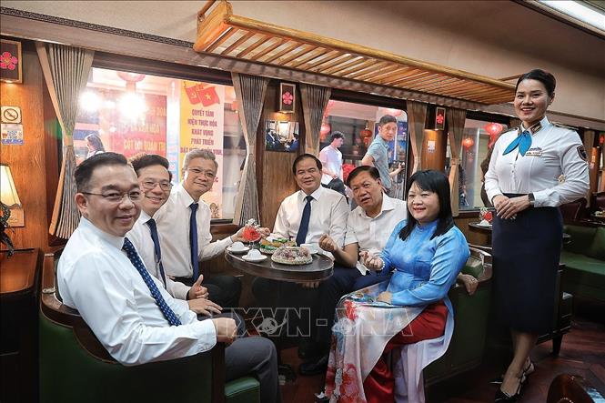 Các đại biểu lưu lại kỷ niệm trên chuyến tàu. Ảnh: Phạm Tuấn Anh - TTXVN