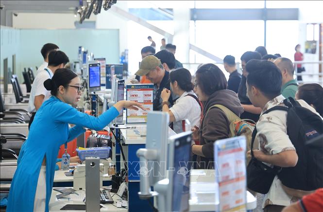Hành khách làm thủ tục tại quầy của Vietnam Airlines, sân bay quốc tế Nội Bài. Ảnh: Quốc Khánh - TTXVN