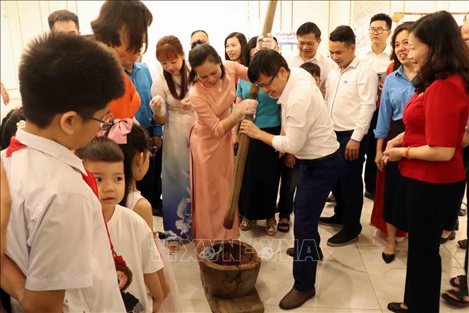 Cuộc thi giã và gói bánh dày tại ngày hội. Ảnh: Thu Hằng-TTXVN 