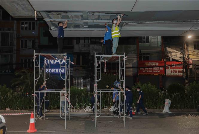 Từ 22h30 ngày 26/6, đội ngũ kỹ sư Hà Nội Metro bắt đầu sửa chữa các tấm ốp Alu bị hỏng do xe quá khổ tại ga Láng, đảm bảo tiến độ và không ảnh hưởng đến giao thông. Ảnh: Phan Phương – TTXVN