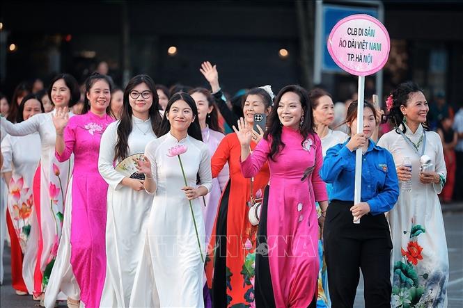 Các thành viên Câu lạc bộ Di sản Áo dài Việt Nam TP. Hà Nội trong trang phục áo dài họa tiết sen tham gia đoàn diễu hành, góp phần tôn vinh vẻ đẹp áo dài Việt Nam. Ảnh: Phạm Tuấn Anh - TTXVN