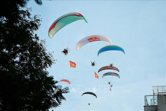 Tiết mục bay dù lượn mang theo cờ Tổ quốc trên bầu trời Hồ Tây. Ảnh: Phạm Tuấn Anh - TTXVN
