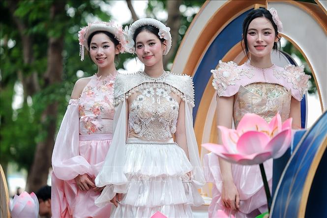 Các người mẫu trong trang phục lấy cảm hứng từ hoa sen trình diễn trên xe hoa. Ảnh: Phạm Tuấn Anh - TTXVN