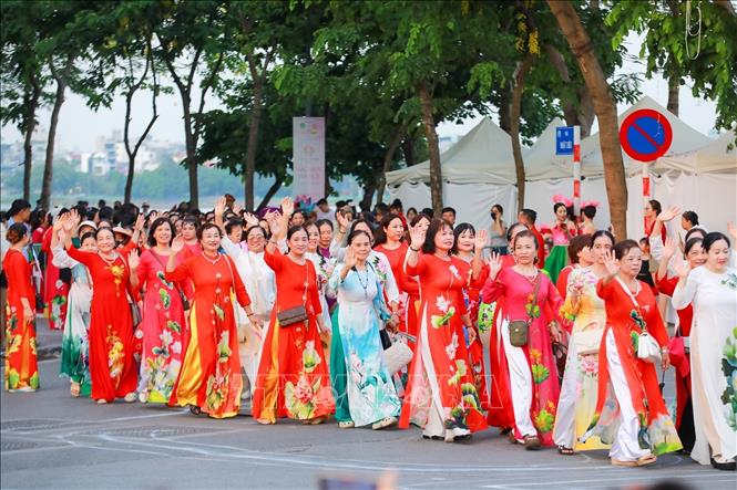 Màn diễu hành của hơn 2000 người mặc áo dài hoạ tiết sen. Ảnh: Khánh Hoà - TTXVN
