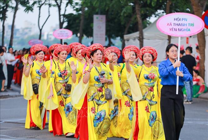 Màn diễu hành của hơn 2000 người mặc áo dài hoạ tiết sen. Ảnh: Khánh Hoà - TTXVN
