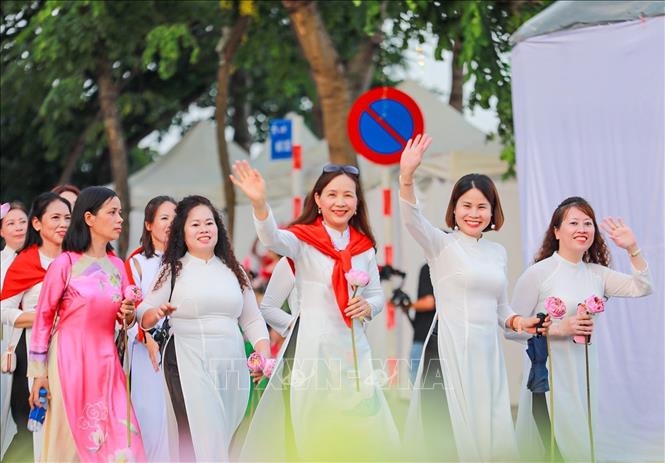 Màn diễu hành của hơn 2000 người mặc áo dài hoạ tiết sen. Ảnh: Khánh Hoà - TTXVN
