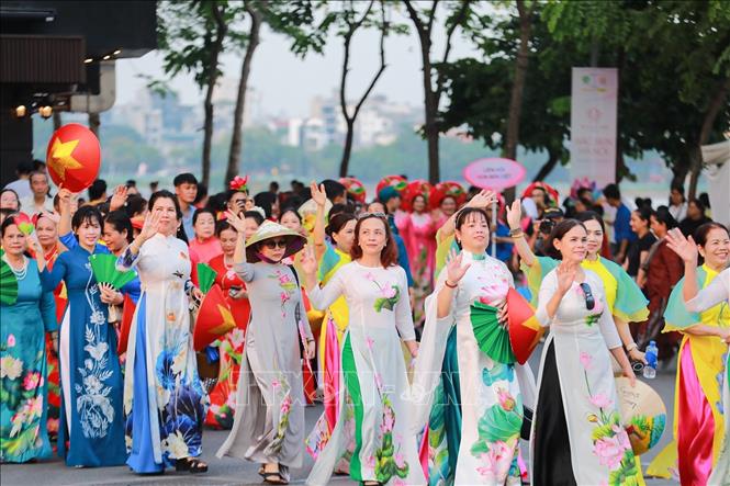 Màn diễu hành của hơn 2000 người mặc áo dài hoạ tiết sen. Ảnh: Khánh Hoà - TTXVN

