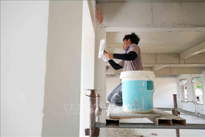 Công nhân khẩn trương hoàn thiện công đoạn sơn bả tường trong các phòng học. Ảnh: Hữu Quyết – TTXVN
