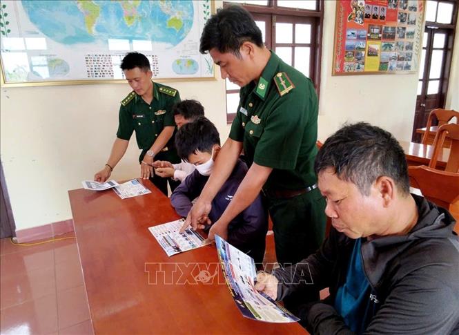 Cán bộ Đồn Biên phòng Lý Hòa cấp phát tờ rơi tuyên truyền, phổ biến những quy định mới của pháp luật. Ảnh: Võ Dung - TTXVN