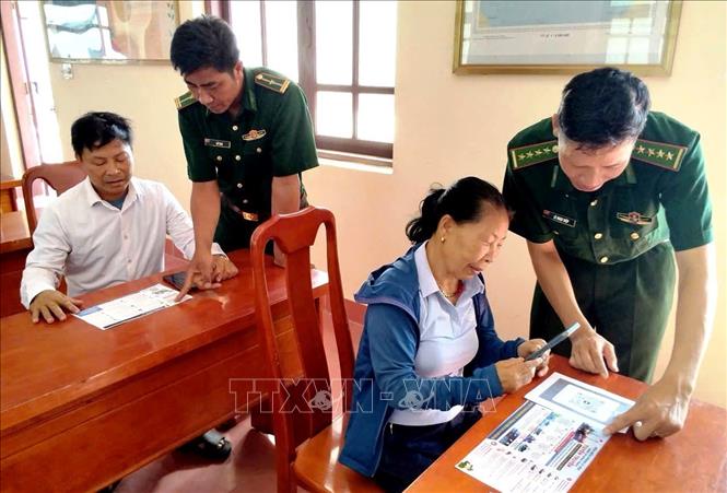 Cán bộ Đồn Biên phòng Lý Hòa trực tiếp hướng dẫn người dân cài đặt, sử dụng phần mềm nhật ký khai thác thủy sản điện tử (eCDT VN) và tham gia nhóm Zalo “Tàu thuyền an toàn”. Ảnh: Võ Dung - TTXVN