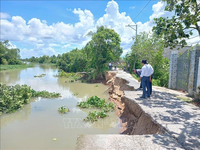 Sạt lở làm hơn một nửa tuyến đường bê tông rộng 4m đổ xuống sông. Ảnh: Công Trí - TTXVN