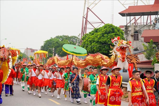 Đoàn rước kéo dài trên bờ đê với sự tham gia của của đông đảo cộng đồng dân cư, tạo nên không khí của lễ hội đặc săc và độc đáo lâu đời. Ảnh: Khánh Hoà - TTXVN