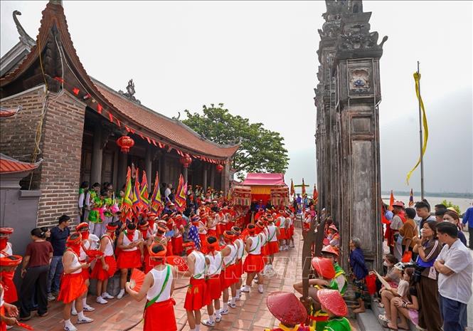 Tượng thánh được đưa ra khu vực sân đình một cách cẩn thận để bắt đầu nghi lễ mộc dục với đội phù giá hùng hậu. Ảnh: Khánh Hoà - TTXVN