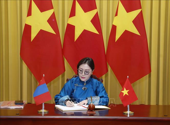 Đại sứ Mông Cổ Hulan Ganbaatar ghi lưu bút. Ảnh: Thống Nhất – TTXVN