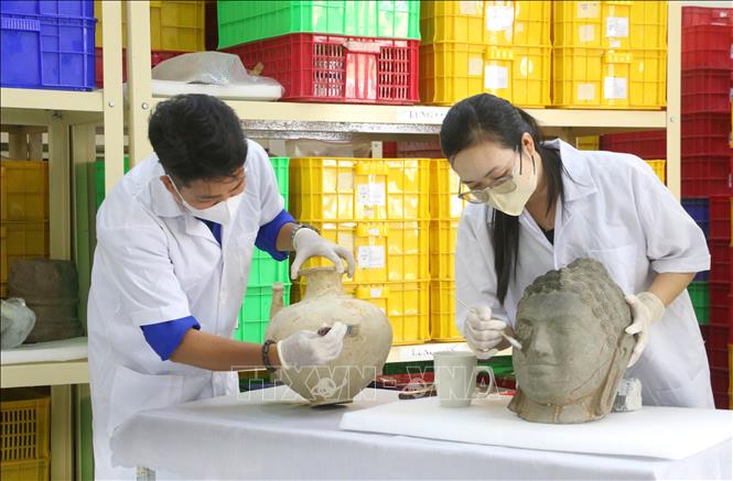 Cán bộ, nhân viên Ban Quản lý Di tích Bet88013 88k Cho Tân Thủ Óc Eo (tỉnh An Giang) đang chỉnh lý, sắp xếp lại kho lưu trữ hiện vật đã được khai quật, phục vụ công tác trung bày và quá trình đánh giá của đoàn chuyên gia quốc tế. Ảnh: Công Mạo - TTXVN