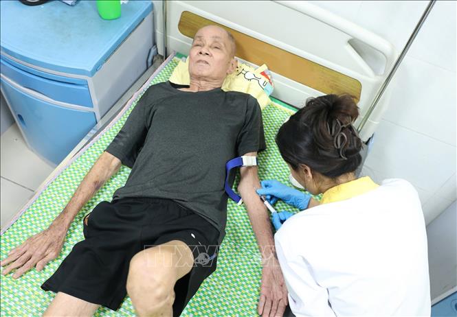 Lực lượng Công an tỉnh Bắc Ninh và Công an xã Yên Phong đã trực tiếp đến tận giường bệnh để hỗ trợ lấy mẫu ADN cho các thân nhân liệt sĩ không thể đến điểm tập trung. Ảnh: Tiến Long/TTXVN phát