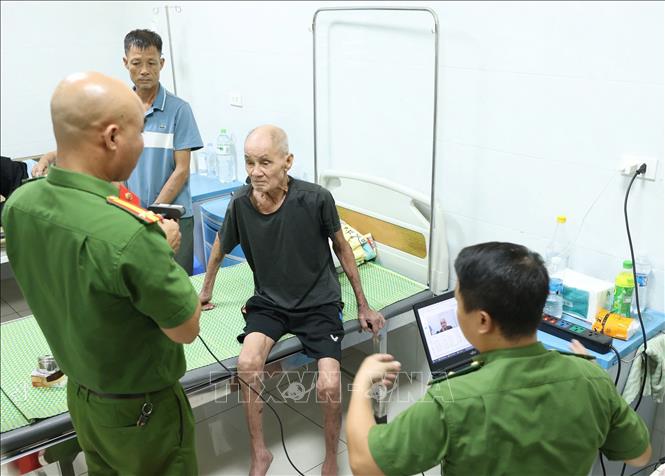 Lực lượng Công an tỉnh Bắc Ninh và Công an xã Yên Phong đã trực tiếp đến tận giường bệnh để hỗ trợ lấy mẫu ADN cho các thân nhân liệt sĩ không thể đến điểm tập trung. Ảnh: Tiến Long/TTXVN phát