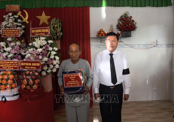 Bí thư Tỉnh ủy An Giang Nguyễn Tiến Hải tặng quà thân nhân liệt sĩ Đặng Văn Dùng, xã Ba Chúc, tỉnh An Giang. Ảnh: Công Mạo-TTXVN  