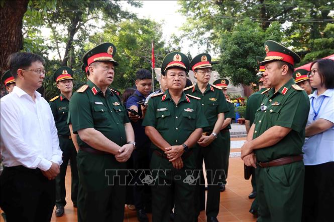 Thiếu tướng  Nguyễn Thành Trung, Chính ủy Bộ Tư lệnh Thành phố Hồ Chí Minh, Phó Trưởng ban Ban Chỉ đạo Thành phố Hồ Chí Minh báo cáo Đại tướng Nguyễn Trọng Nghĩa về công tác tìm kiếm, quy tập hài cốt liệt sĩ tại công viên Lê Thị Riêng. Ảnh: Xuân Khu-TTXVN