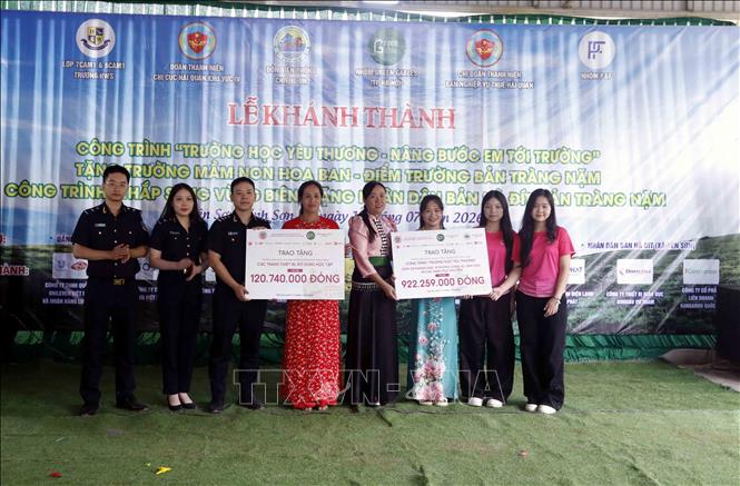 Trao biểu trưng số tiền tài trợ cho Trường Mầm non Hoa Ban. Ảnh: Quang Quyết - TTXVN