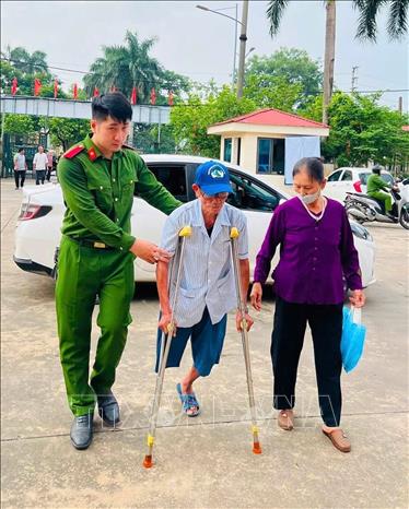 Công an tỉnh Phú Thọ hỗ trợ thân nhân liệt sĩ đến điểm thu nhận ADN. Ảnh: Nguyễn Thảo - TTXVN