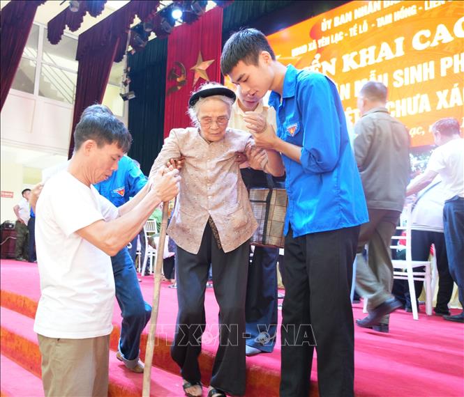 Đoàn viên thanh niên xã Yên Lạc (Phú Thọ) hỗ trợ thân nhân liệt sĩ đến thu nhận mẫu ADN. Ảnh: Nguyễn Thảo - TTXVN