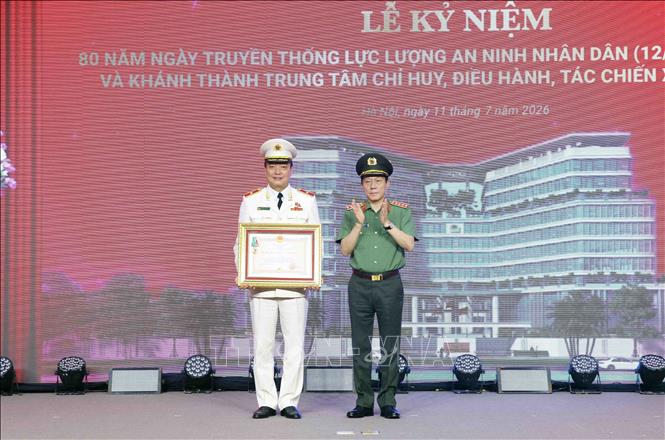 Đại tướng Lương Tam Quang, Bộ trưởng Bộ Công an trao Huân chương Bảo vệ Tổ quốc hạng Ba cho Thiếu tướng Nguyễn Bá Tuấn, Phó Cục trưởng Cục Quản lý xuất nhập cảnh. Ảnh: Phạm Kiên - TTXVN