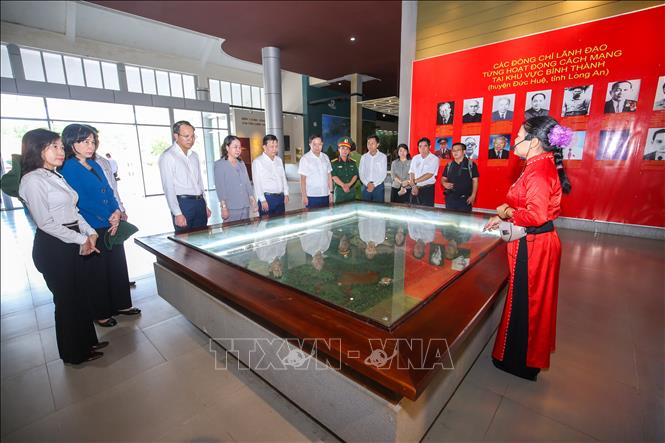Tham quan Khu di tích lịch sử cách mạng Bình Thành, du khách lắng nghe những câu chuyện được kể qua các kỷ vật, tư liệu, thêm hiểu và trân trọng giá trị của hòa bình hôm nay. Ảnh: Giang Phương - TTXVN