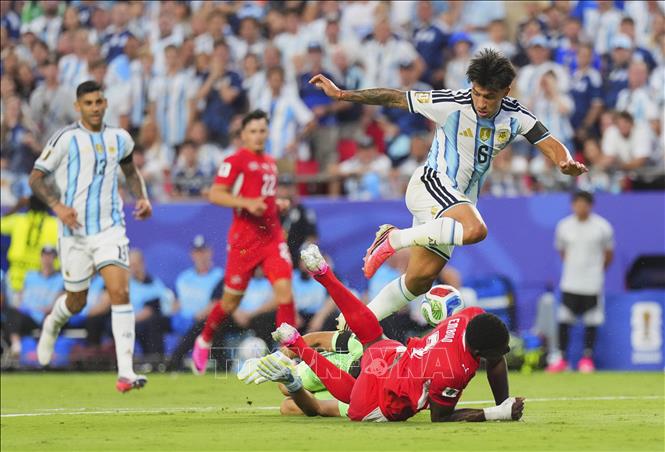 Lisandro Martinez (trên) của Argentina đi bóng dũng mãnh trước cầu thủ Thuỵ Sĩ. Ảnh: THX/TTXVN phát

