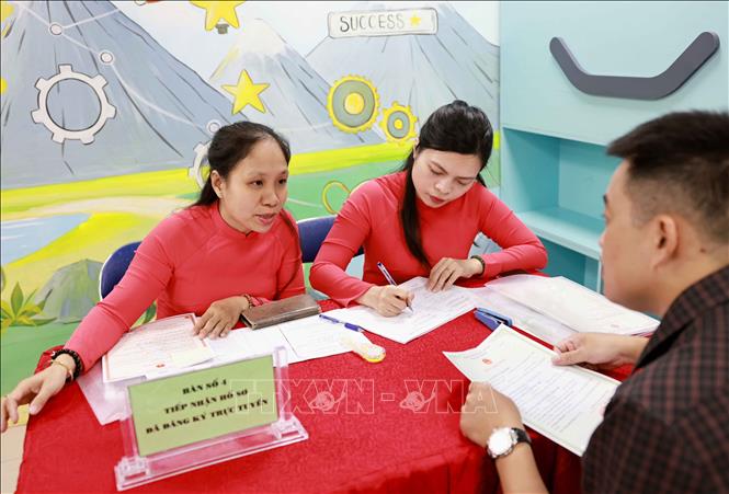 Đội ngũ cán bộ tuyển sinh luôn niềm nở, tận tình giải đáp các câu hỏi của phụ huynh, tạo tâm lý yên tâm và tin tưởng khi thực hiện đăng ký cho con mình. Ảnh: Thanh Tùng - TTXVN